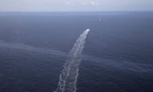 The wake of a supply vessel heading towards a working platform crosses over an oil sheen drifting from the site of the former Taylor Energy oil rig in the Gulf of Mexico, off the coast of Louisiana in 2015