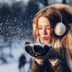 woman blowing snow flakes