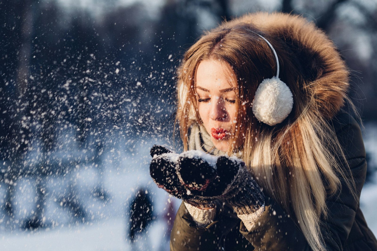 woman blowing snow flakes