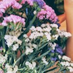 a bunch of flowers and a tattooed hand