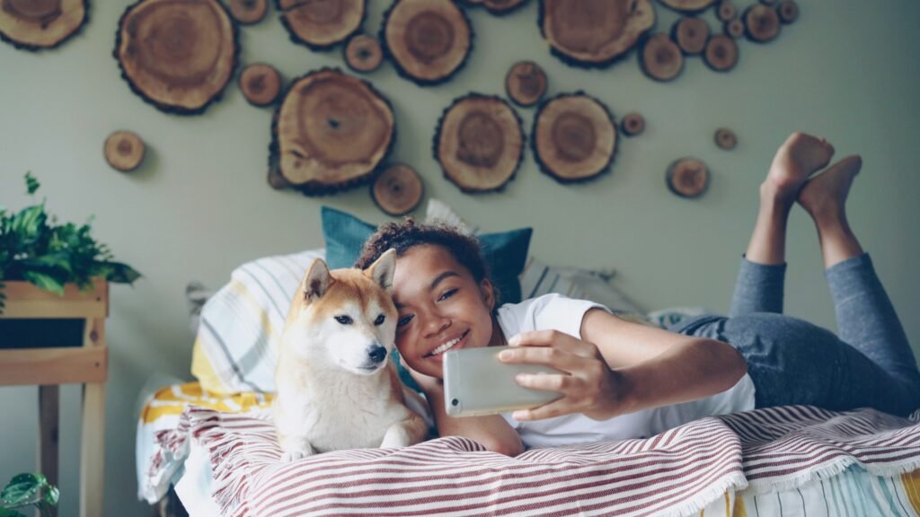 A little girl taking a selfie with her pet dog