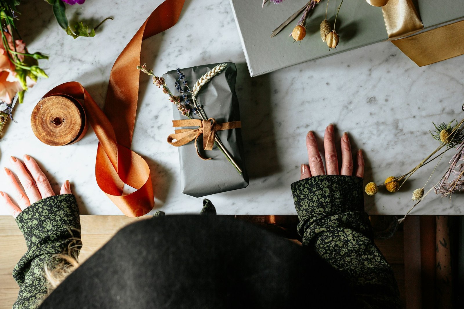 Gifts are placed on the table in front of a woman